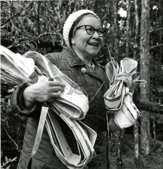 Grace Wilson gathering cedar bark bundles.