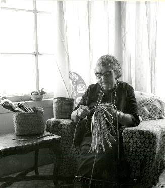 Carrie Weir weaving a cedar bark basket.